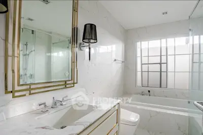 Luxurious bathroom with marble finishes and elegant fixtures in modern real estate property.