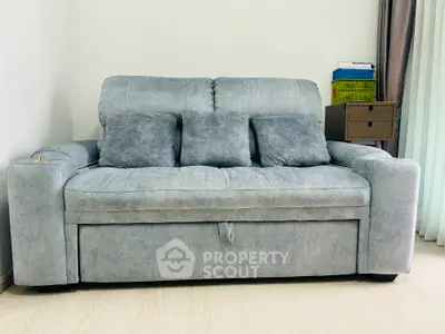 Cozy gray sofa in modern living room with natural light and minimalist decor