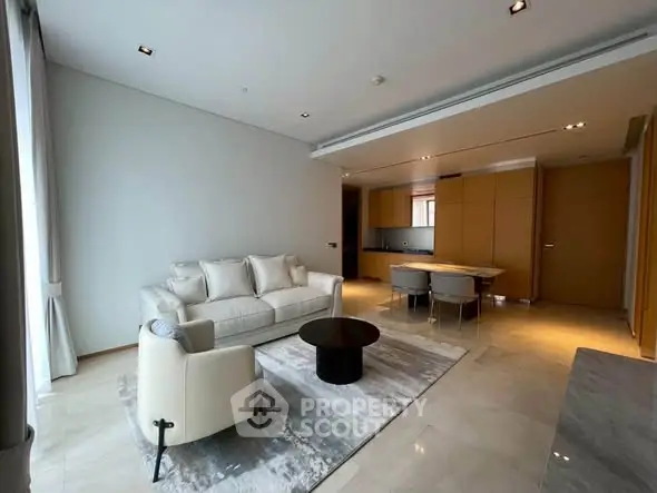 Modern living room with elegant furniture and open kitchen layout in luxury apartment.