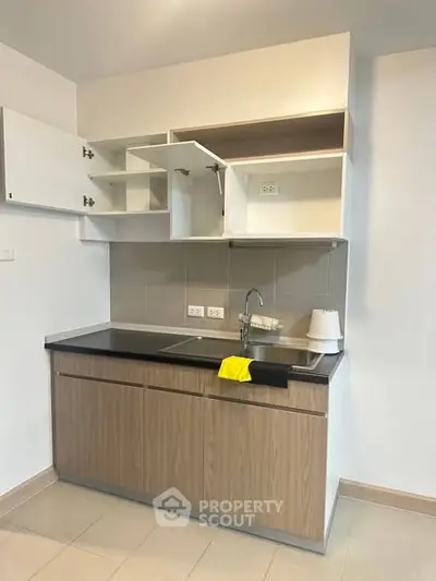 Modern compact kitchen with open cabinets and sleek design