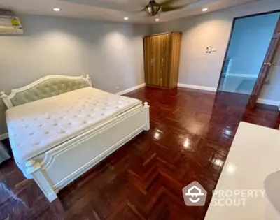 Spacious bedroom with elegant wooden flooring and stylish furniture