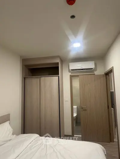 Cozy bedroom with built-in wardrobe and air conditioning unit, ideal for comfortable living.