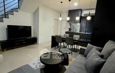 Modern living room with sleek furniture and open kitchen layout, perfect for contemporary living.