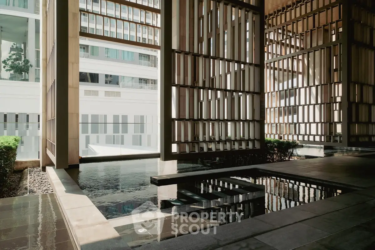 Modern architectural design with serene water feature and stylish lattice walls.