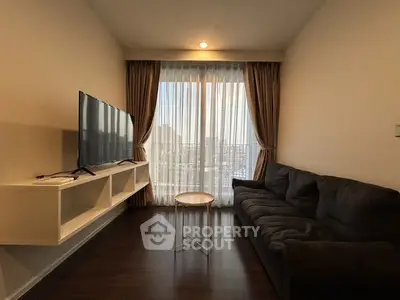 Modern living room with sleek TV setup and cozy sofa, offering a bright and inviting atmosphere.