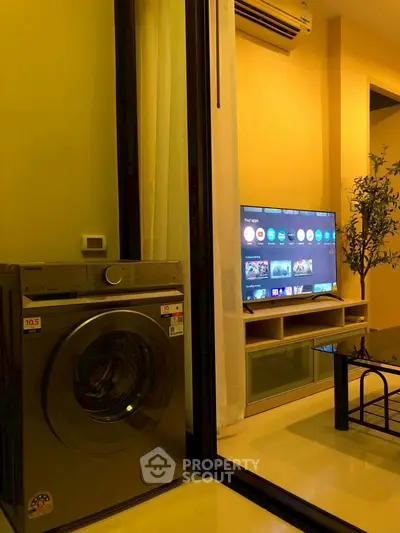 Modern living room with washing machine and smart TV setup
