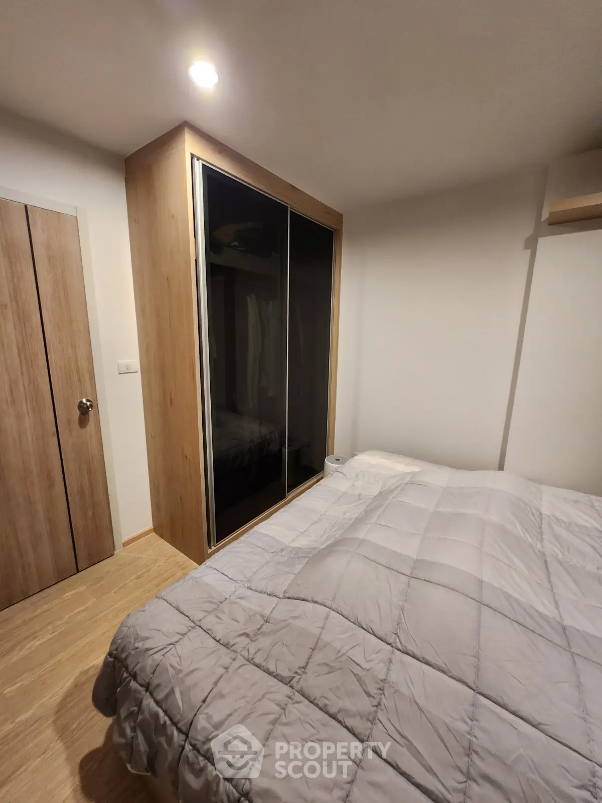 Cozy bedroom with modern wardrobe and soft lighting, perfect for relaxation.