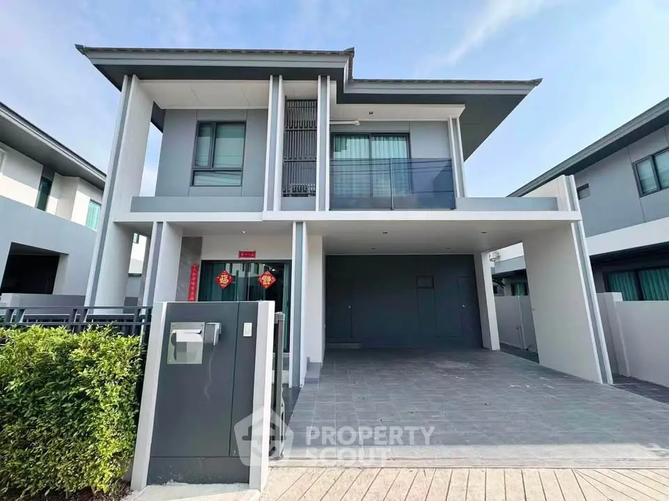 Modern two-story house with sleek design and spacious driveway in a serene neighborhood.