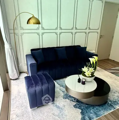 Elegant living room with navy sofa, modern coffee table, and stylish floor lamp.