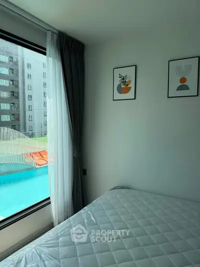 Modern bedroom with pool view, large window, and stylish decor in a contemporary apartment.