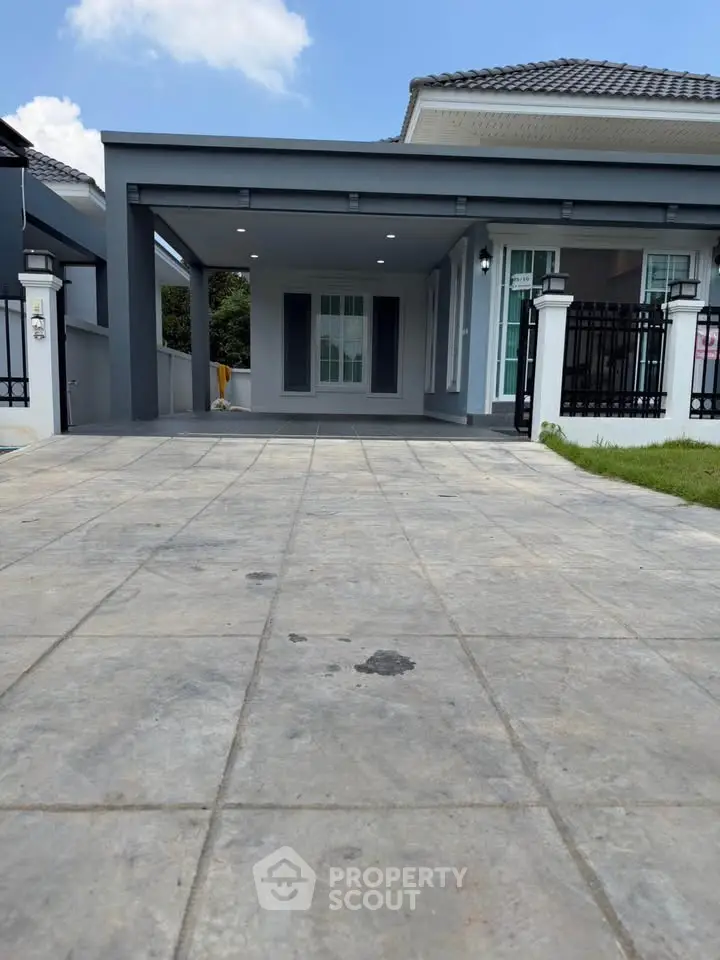 Modern single-story house with spacious driveway and sleek exterior design.