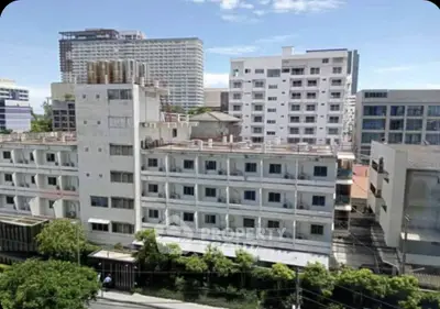 Urban apartment buildings with clear blue sky, showcasing city living.