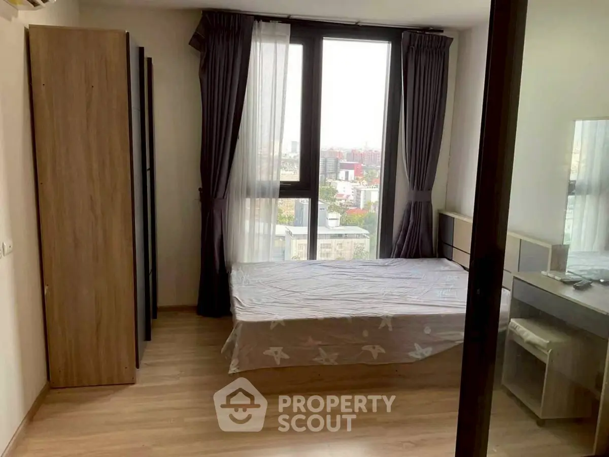 Cozy bedroom with city view, featuring a single bed and modern furnishings, perfect for urban living.