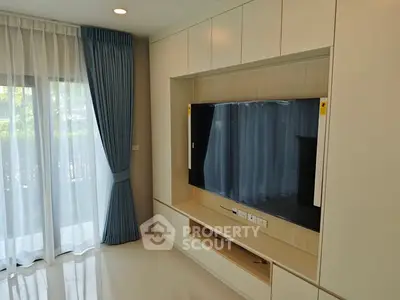 Modern living room with built-in TV unit and large window with curtains