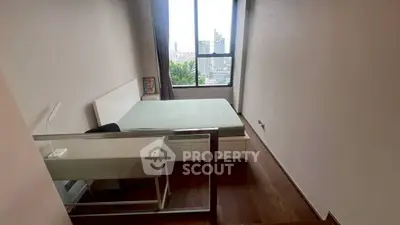 Modern bedroom with city view and sleek furniture in high-rise apartment.