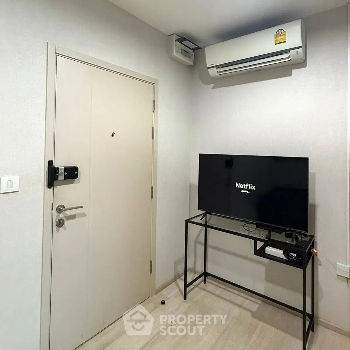 Modern living room with air conditioning and TV setup, perfect for cozy entertainment.