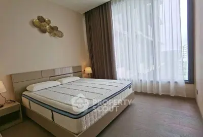 Spacious bedroom with large window and modern decor in a luxury apartment.