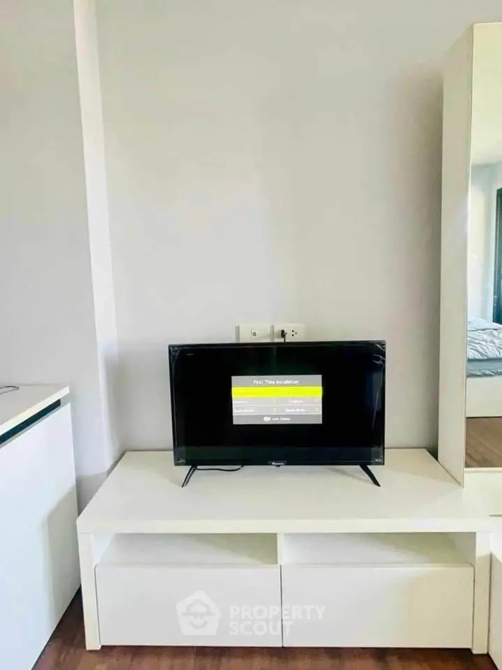 Modern living room with sleek TV setup and minimalist furniture design.