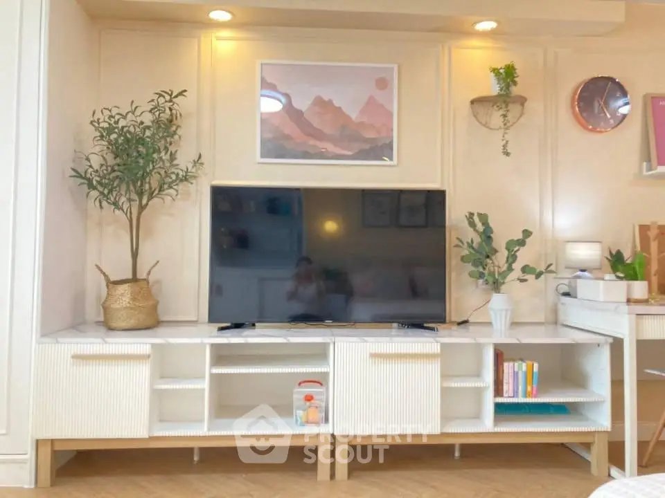 Stylish living room with modern TV stand, decorative plants, and elegant wall art.