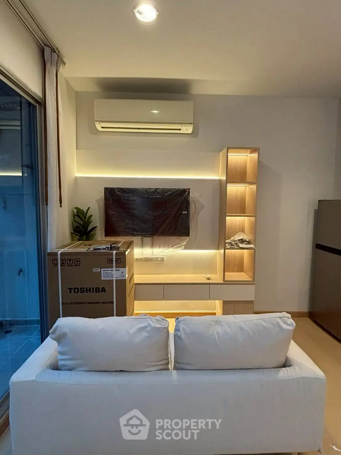 Modern living room with sleek furniture and air conditioning unit