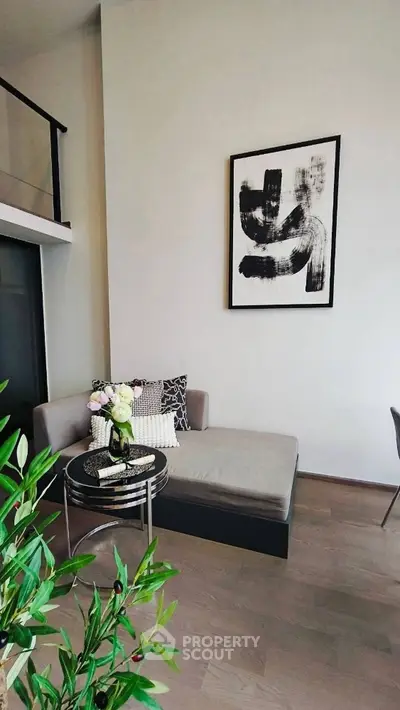 Modern living room with stylish decor and abstract art on the wall.