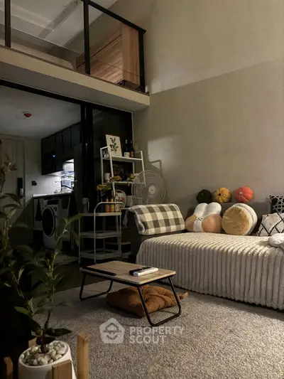 Cozy modern living room with mezzanine, stylish decor, and open kitchen layout.