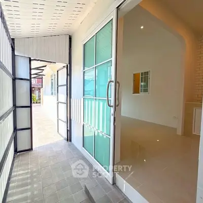 Bright entrance with sliding glass doors leading to a modern interior