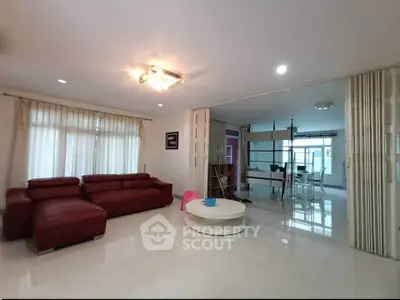 Spacious modern living room with red leather sofa and elegant lighting