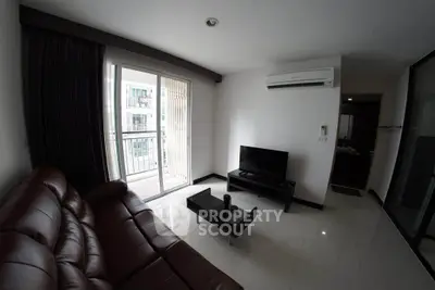 Modern living room with sleek furniture and balcony access in a stylish apartment.