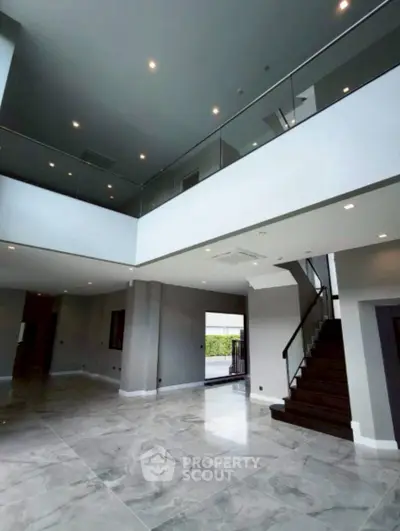 Spacious modern living room with high ceilings and elegant staircase