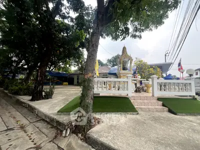 Charming outdoor area with lush greenery and traditional architectural features, perfect for serene living.