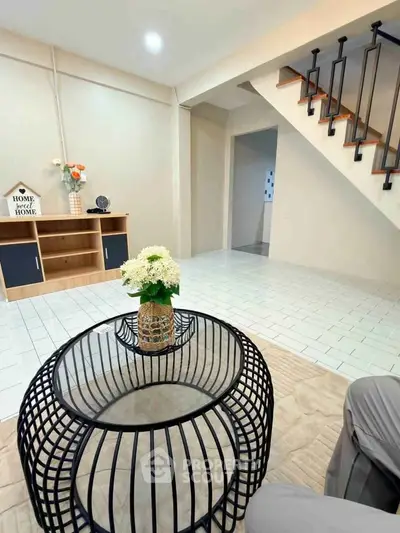 Charming living room with modern decor and stylish staircase, perfect for cozy family gatherings.