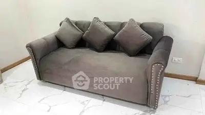 Elegant gray sofa with plush cushions in a modern living room setting.