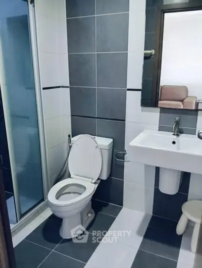 Modern bathroom with sleek tiles and contemporary fixtures in a stylish apartment.