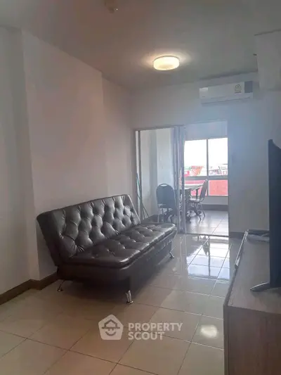 Modern living room with sleek black sofa and bright natural light