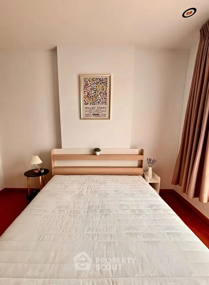 Cozy bedroom with minimalist decor and natural light, featuring a comfortable bed and stylish side table.