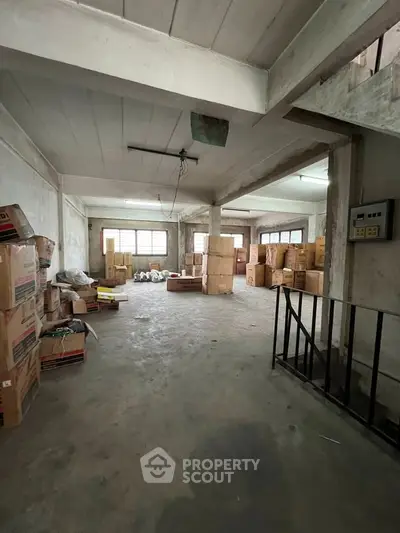 Spacious storage area with boxes and concrete flooring, ideal for warehouse use.