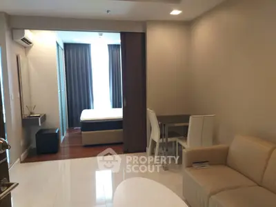 Modern open-plan living room with dining area and view into bedroom