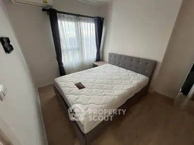 Cozy bedroom with modern design featuring a comfortable bed and natural light from large windows.