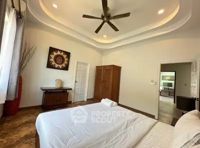 Spacious bedroom with elegant decor and ceiling fan in modern home