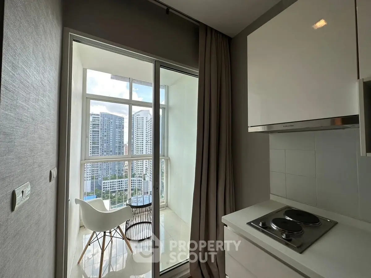 Modern kitchen with balcony view in high-rise apartment