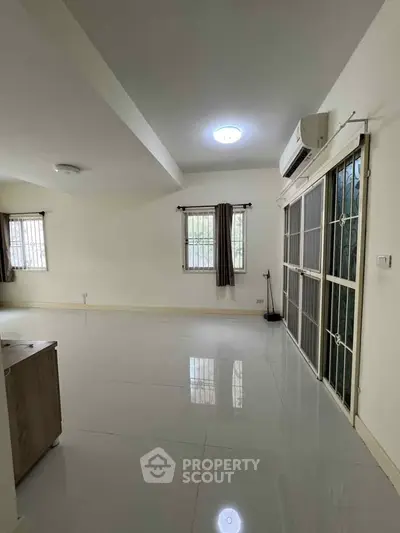 Spacious living room with large windows and air conditioning in modern home.