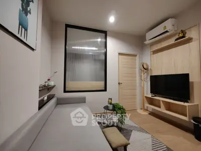 Modern living room with sleek furniture and wall-mounted TV, featuring a cozy ambiance and stylish decor.