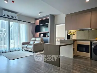 Modern open-plan living room with sleek kitchen and natural light
