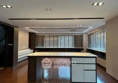 Spacious modern living room with sleek wooden flooring and large windows for natural light.