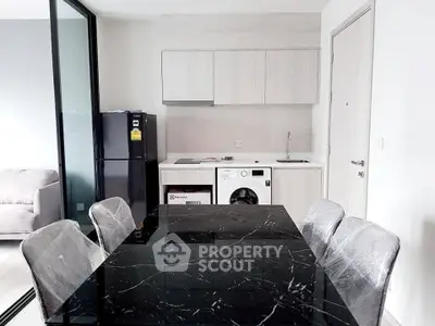 Modern kitchen with sleek black marble dining table and built-in appliances in a stylish apartment.