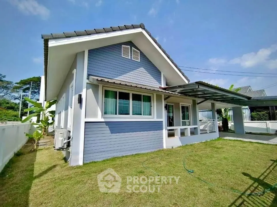 Charming blue and white single-story house with lush green lawn and modern design.