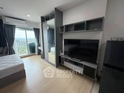 Modern bedroom with balcony view, sleek TV setup, and ample natural light in a stylish apartment.
