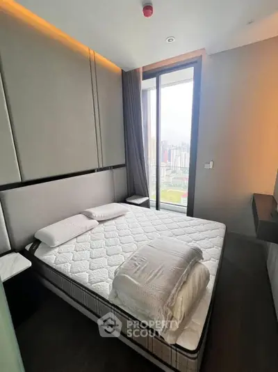 Modern bedroom with city view, featuring a cozy bed and sleek design in a high-rise apartment.