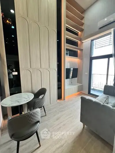 Modern living room with high ceilings, elegant wood paneling, and a cozy seating area.